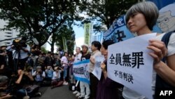 Activists hold placards during a rally in front of the Tokyo District Court in Tokyo, Sept. 19, 2019, after the court acquitted three former officials from the firm that operated the Fukushima nuclear plant.