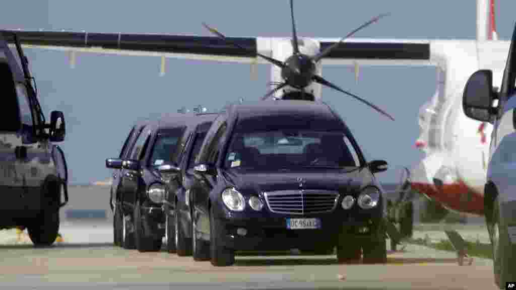 Mortuary vehicles wait outside a hangar where some of the bodies of Thursday's shipwreck are held, at the airport of Lampedusa, Italy, Oct. 4, 2013.