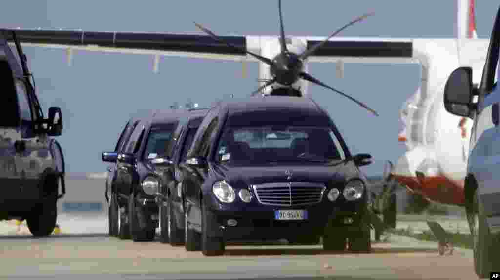 Mortuary vehicles wait outside a hangar where some of the bodies of Thursday's shipwreck are held, at the airport of Lampedusa, Italy, Oct. 4, 2013.