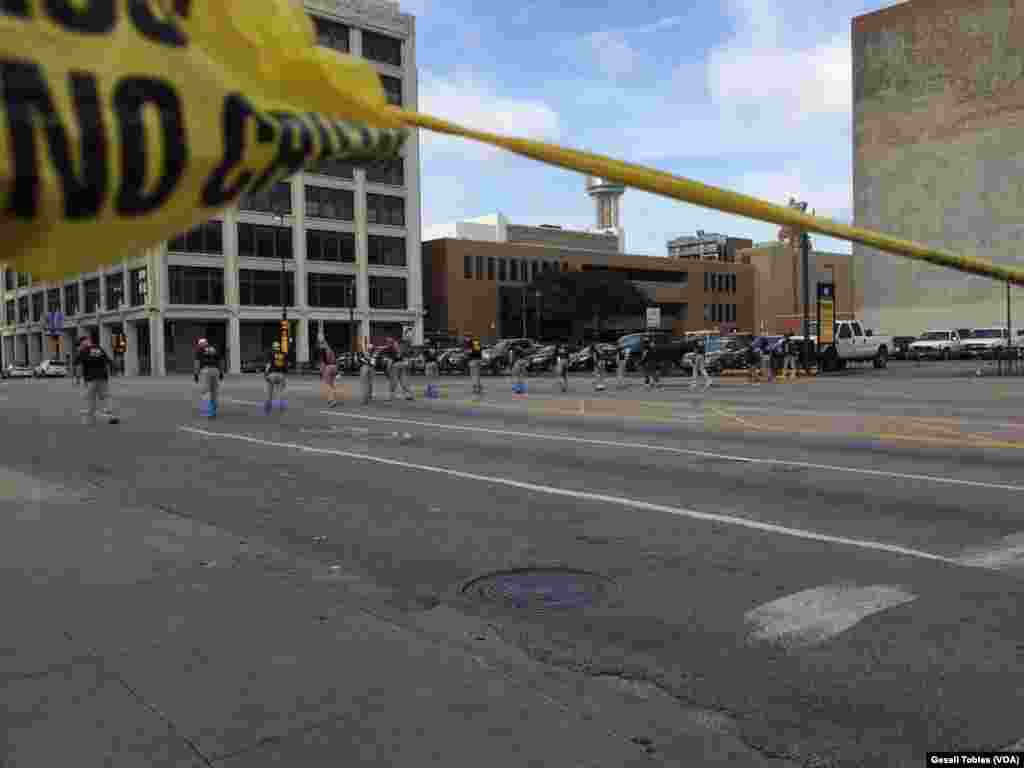 Law enforcement personnel investigate a mass shooting scene after an attack that killed and wounded Dallas police officers, in Dallas, Texas, July 8, 2016.