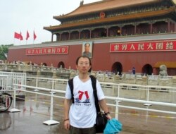 FILE - Chinese pro-democracy activist Hu Jia stands in front of the Tiananmen Gate in Beijing, June 27, 2007.