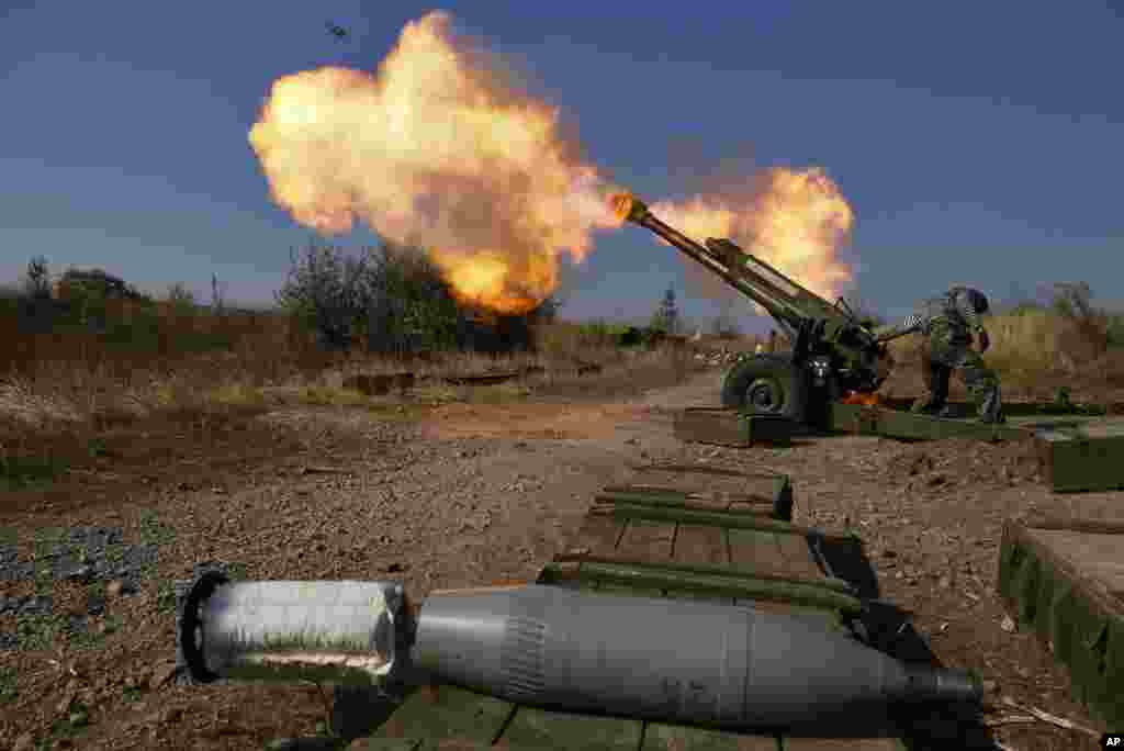 Pro-Russian rebels fire artillery toward a Ukrainian position at Donetsk Sergey Prokofiev International Airport, outskirts of Donetsk, eastern Ukraine, Oct. 14, 2014.