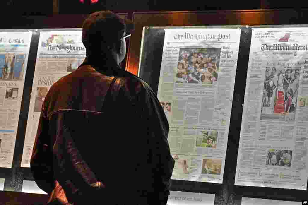 A passersby examine the main photo of the stampede in Cambodia on the front page of Washington Post of November 23, 2010.