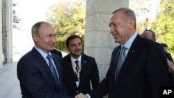 Russian President Vladimir Putin, left, and Turkish President Recep Tayyip Erdogan shake hands before their meeting in the Bocharov Ruchei residence in the Black Sea resort of Sochi, Russia, Oct. 22, 2019.