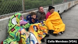 Migrants from Venezuela, Cuba and Guatemala wait at bridge between Matamoros, Mexico and Brownsville, Texas for immigration officials to allow them to turn themselves in and ask for asylum in US, Nov. 12, 2018.