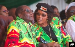 FILE - Zimbabwean President Robert Mugabe and his wife, Grace, follow proceedings during a youth rally in Marondera about 100 kilometers east of Harare, June, 2, 2017.