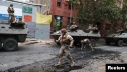 Soldados chilenos patrullan una calle de Santiago el domingo 20 de octubre de 2019, luego del toque de queda declarado por el gobierno el sábado por la noche. Reuters, Iván Alvarado.