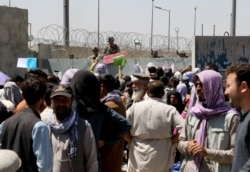 Crowds of people show their documents to U.S. troops outside the airport in Kabul, Afghanistan August 26, 2021. (REUTERS/Stringer)