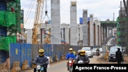 FILE - Motorists drive on Mombasa road, next to the ongoing construction site of the Nairobi Expressway, undertaken by the Chinese contractor China Road and Bridge Corporation, in Nairobi, Kenya, July 12, 2021.