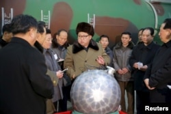 지난해 3월 김정은 북한 국무위원장이 핵무기 연구 부문 과학자, 기술자들을 만나 핵무기 병기화 사업을 지도하는 모습을 조선중앙통신이 보도했다. 사진 아래쪽에 핵탄두 기폭장치 추정 물체가 보인다.