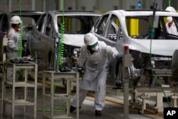 FILE - Employees work in the new multibillion-dollar Honda car plant in Celaya, in the central Mexican state of Guanajuato, Feb. 21, 2014.