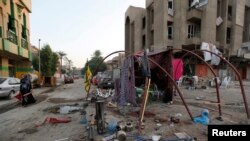 A woman walks past the site of a car bomb attack at Palestine Street in Baghdad, Nov. 2, 2014.