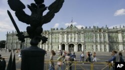 FILE - People make their way past the Winter Palace, the main building of Russia's famed State Hermitage Museum, St.Petersburg, Russia, Aug. 1, 2006