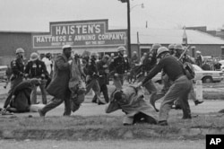 State troopers swing billy clubs to break up a civil rights voting march in Selma, Ala., March 7, 1965. John Lewis, chairman of the Student Nonviolent Coordinating Committee (in the foreground) is being beaten by a state trooper.