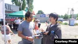 Sameth Mell, left, is seen listening to a local resident at a BBQ gathering, Seattle, August 19, 2017. (Courtesy of Sameth Mell)