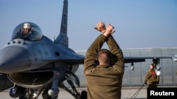 На фото: Льотчик ВПС США та літак F-16 Fighting Falcon, Румунія, 17 лютого 2022 р., REUTERS