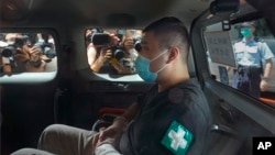 香港首位被控涉嫌違反國安法的唐英傑坐著輪椅由警車押解至法院應訊。 （2020年7月6日）
