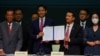 Ketua MFP Pita Limjaroenrat (jas biru) menunjukkan perjanjian bersama yang ditandatangani bersama tujuh pemimpin koalisi lainnya, di Bangkok hari Senin (22/5). 