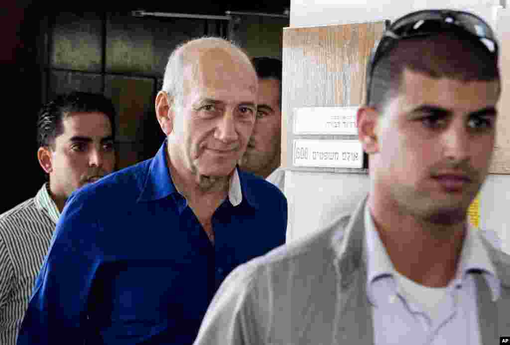 Former Israeli prime minister Ehud Olmert (center) leaves the Tel Aviv District Court, in Israel, May 13, 2014. 