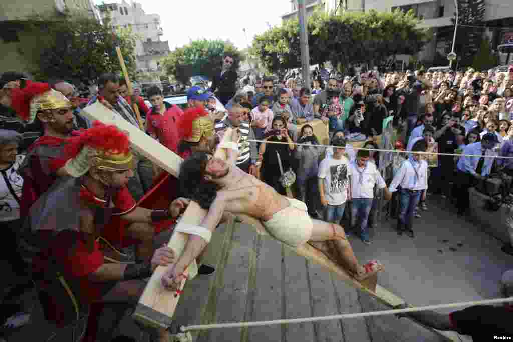 Lebanese Christians take part in a reenactment of the crucifixion of Jesus Christ on Good Friday beside Mar Joseph Chruch, Dhour Sarba, Lebanon, April 18, 2014. 