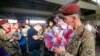 FILE - Sean Smith, a paratrooper with the 1st Brigade Combat Team, 82nd Airborne Division, kisses his daughter Olivia Rose Smith, 10 months, after returning home from Afghanistan at Pope Army Airfield in Fort Bragg, North Carolina, Nov. 5, 2014.