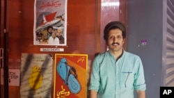 In this Aug. 25, 2017 photo, Saudi filmmaker Ali Kalthami stands next to the poster for his film "Wasati" or "Moderate" and two other Saudi short films recently shown at Cinema Akil in Dubai, United Arab Emirates.