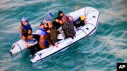 Dalam foto yang dirilis oleh Angkatan Laut Perancis menunjukkan para migran menaiki perahu karet setelah disergap oleh otoritas Perancis di pelabuhan Calais, utara Perancis, 25 Desember 2018.