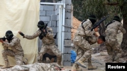 Libyan security forces trained by the Turkish military demonstrate their skills during a graduation ceremony in Khums, Libya, April 8, 2021. 