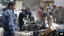 Pasukan keamanan Irak memeriksa lokasi serangan bom mobil di kota Basra, Irak selatan, Minggu (9/9).