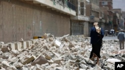 FILE - A Houthi rebel is seen walking amid the rubble left by Saudi-led airstrikes in Sana'a, Yemen, Sept. 16, 2015.