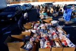 People line up in their cars in the parking lot of St. James Presbyterian Church in Littleton, Colorado, to receive food donations from Food Bank of the Rockies ahead of Thanksgiving, Nov. 25, 2020.