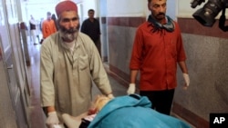 Petugas membawa jenazah pekerja bantuan Finlandia yang tewas di Herat, Afghanistan barat (24/7).