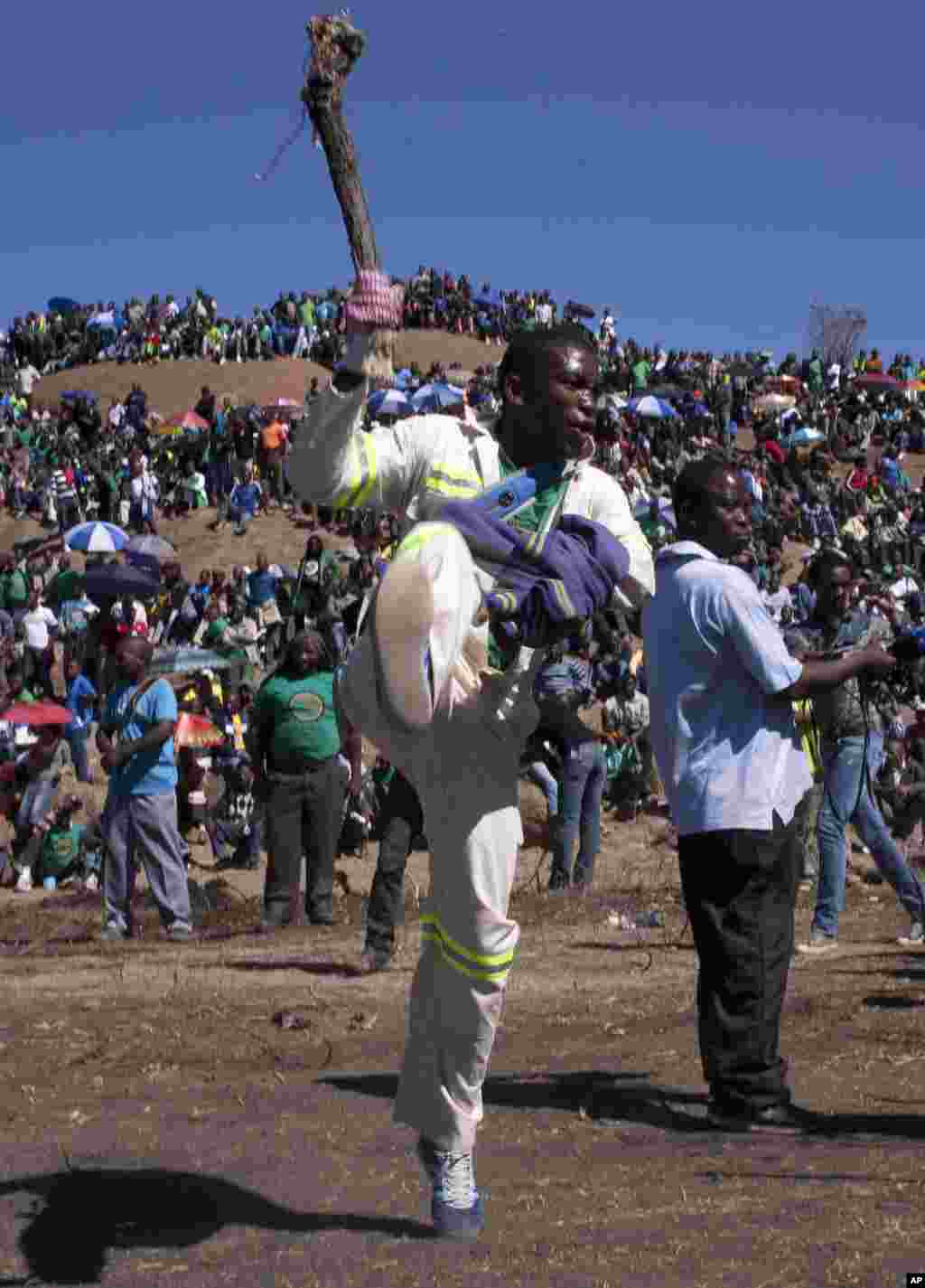 Mine workers dance before a memorial service near the Lonmin's platinum mine in Marikana, South Africa, August 16, 2013.