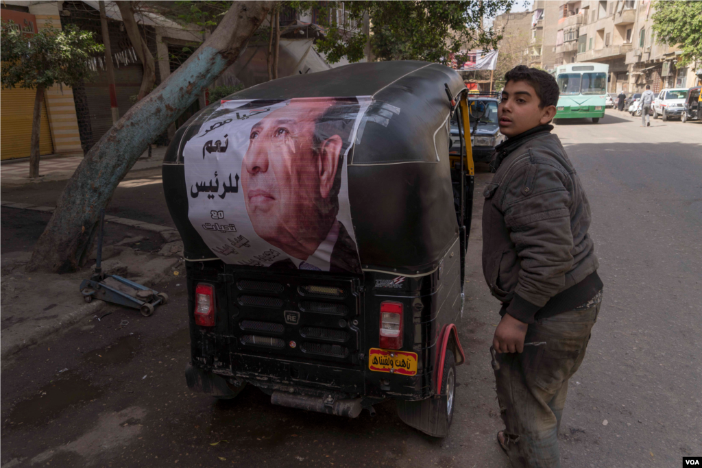 A young driver in Cairo shows off an al-Sissi campaign banner calling voters to say 'Yes to the President.' Many Egyptians see al-Sissi as the only choice in this election, March 26, 2018. (H. Elrasam for VOA)