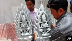One of the four new statues is positioned by a worker from the World Monuments Fund.