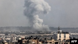 A smoke plume erupts over Khan Yunis from Rafah in the southern Gaza strip during Israeli bombardment on Dec. 27, 2023, amid continuing battles between Israel and the Palestinian Hamas militant group.