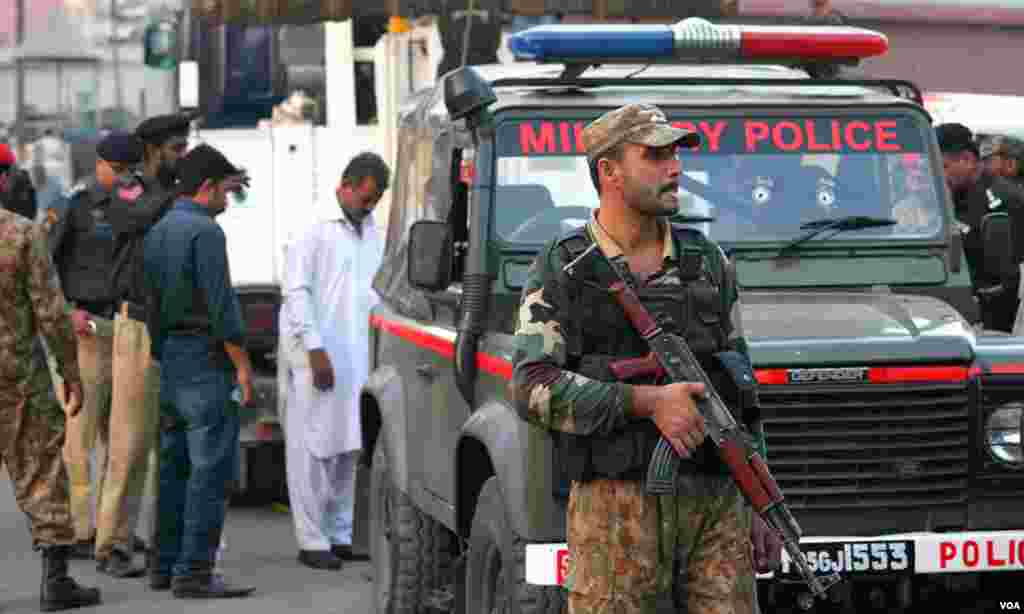  سیکورٹی اہلکار الرٹ کھڑا ہے، پس منظر میں ایم پی کی جیپ نظر آرہی ہے