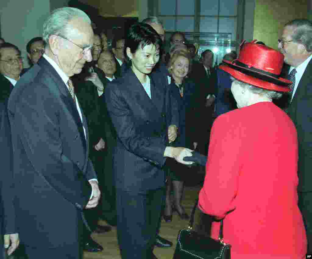 1999年10月21日,在伦敦的大英博物馆,新闻集团首席执行官兼董事长默多克( Rupert Murdoch)对英国女王介绍其夫人邓文迪。当时正值中国国家主席江泽民访问英国,大英博物馆举办关于中国的展览。在中国出生的邓文迪1997年在香港结识了出生于澳大利亚、后成为美国公民的默多克。1999年,默多克与其爱沙尼亚裔的第二任妻子安娜离婚。协议生效17天后,他迎娶了当时32岁的邓文迪。