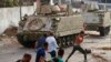 Supporters of Prime Minister-designate Saad Hariri, who stepped down Thursday, clash with Lebanese soldiers in Beirut, Lebanon, July 15, 2021. 