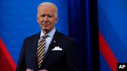 President Joe Biden stands on stage during a break in a televised town hall event at Pabst Theater, Tuesday, Feb. 16, 2021, in Milwaukee. (AP Photo/Evan Vucci)