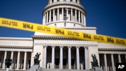 Jalan menuju pintu masuk gedung National Capitol di Havana, Kuba, diblokir dengan pita kuning, Selasa, 13 Juli 2021. Pengamanan diperketat menyusul aksi protes anti-pemerintah akhir pekan yang jarang terjadi di negara tersebut. (Foto: AP/Eliana Aponte)
