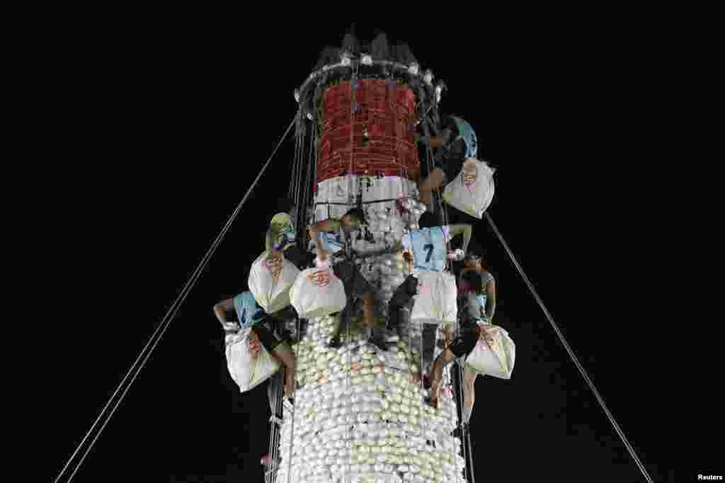 Participants take part in a bun scrambling competition during Bun Festival at Hong Kong's Cheung Chau island. The festival celebrates the islanders' deliverance from famine many centuries ago and is meant to placate ghosts and restless spirits.