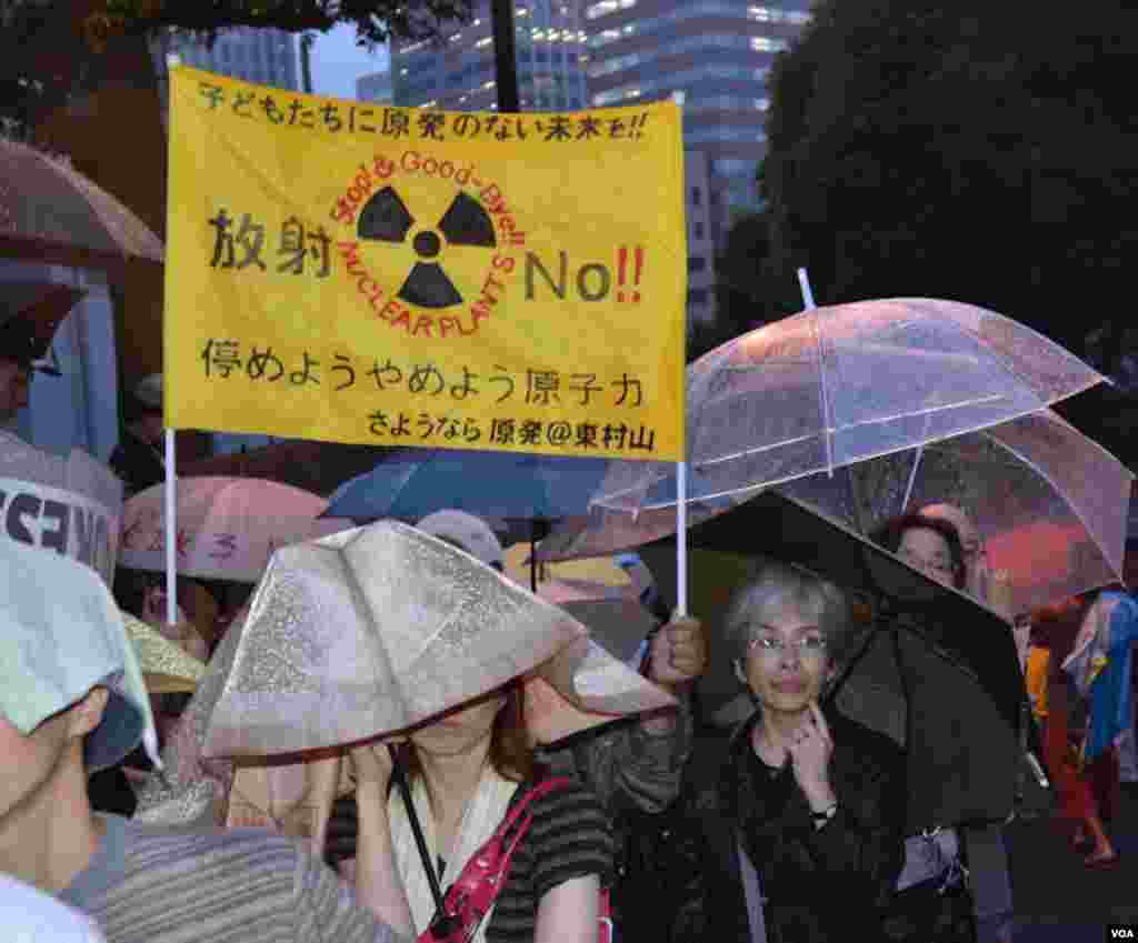 Protesters carry anti-nuclear banners and umbrellas, Tokyo, Japan, July 6, 2012. (S.L. Herman/VOA)