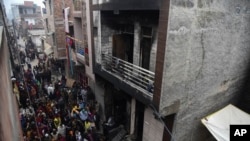 Warga berkumpul di sekitar gudang tempat terjadinya kebakaran pada dini hari Senin, 23 Desember 2019 di daerah Kirari, New Delhi, India.