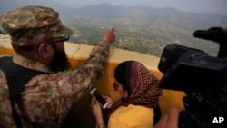 A Pakistan army officer points out the Indian forward area posts to journalists at Bagsar post on the Line of Control that divides Kashmir between Pakistan and India, on October 1, 2016. According to a report, Prime Minister Nawaz Sharif urged spy chief Rizwan Akhtar to take action in the region against three militant groups dedicated to fighting Indian forces. 
