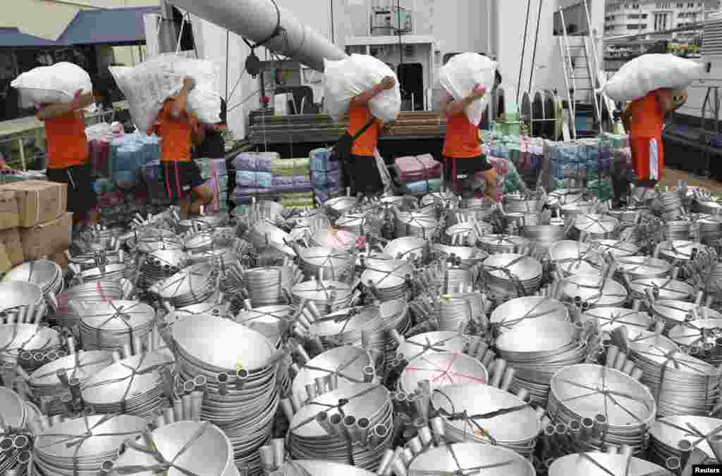 Members of the Philippine Coast Guard carry sacks filled with relief goods to load on-board the BRP Corregidor at a port in Manila, Oct. 16, 2013.