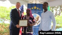 Les représentants de la coopérative la Semence Divine, recevant la convention de financement de l’Ambassadeur Eric Stromayer, Lomé, le 1er octobre 2019. (VOA/Kayi Lawson)