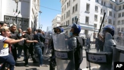 FILE - Demonstrators face police officers in Algiers, May 7, 2021, as a crowd of protesters marched in the streets of Algeria's capital in support for the Hirak pro-democracy movement.