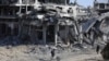 Palestinos caminan en medio de la destrucción dejada por ofensiva terrestre y aérea israelí tras su retirada de Khan Yunis, en el sur de la Franja de Gaza, el domingo 7 de abril de 2024. 