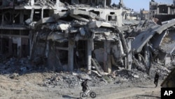 Palestinos caminan en medio de la destrucción dejada por ofensiva terrestre y aérea israelí tras su retirada de Khan Yunis, en el sur de la Franja de Gaza, el domingo 7 de abril de 2024. 